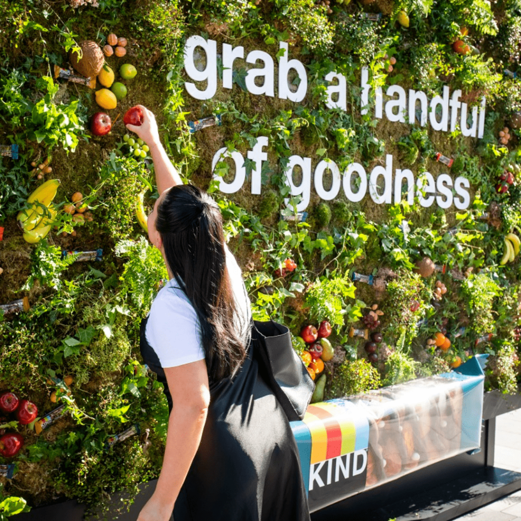 KIND's "Grab and Go" billboard has varieties of fruits and KIND cereal bars hanging from the "tree". 