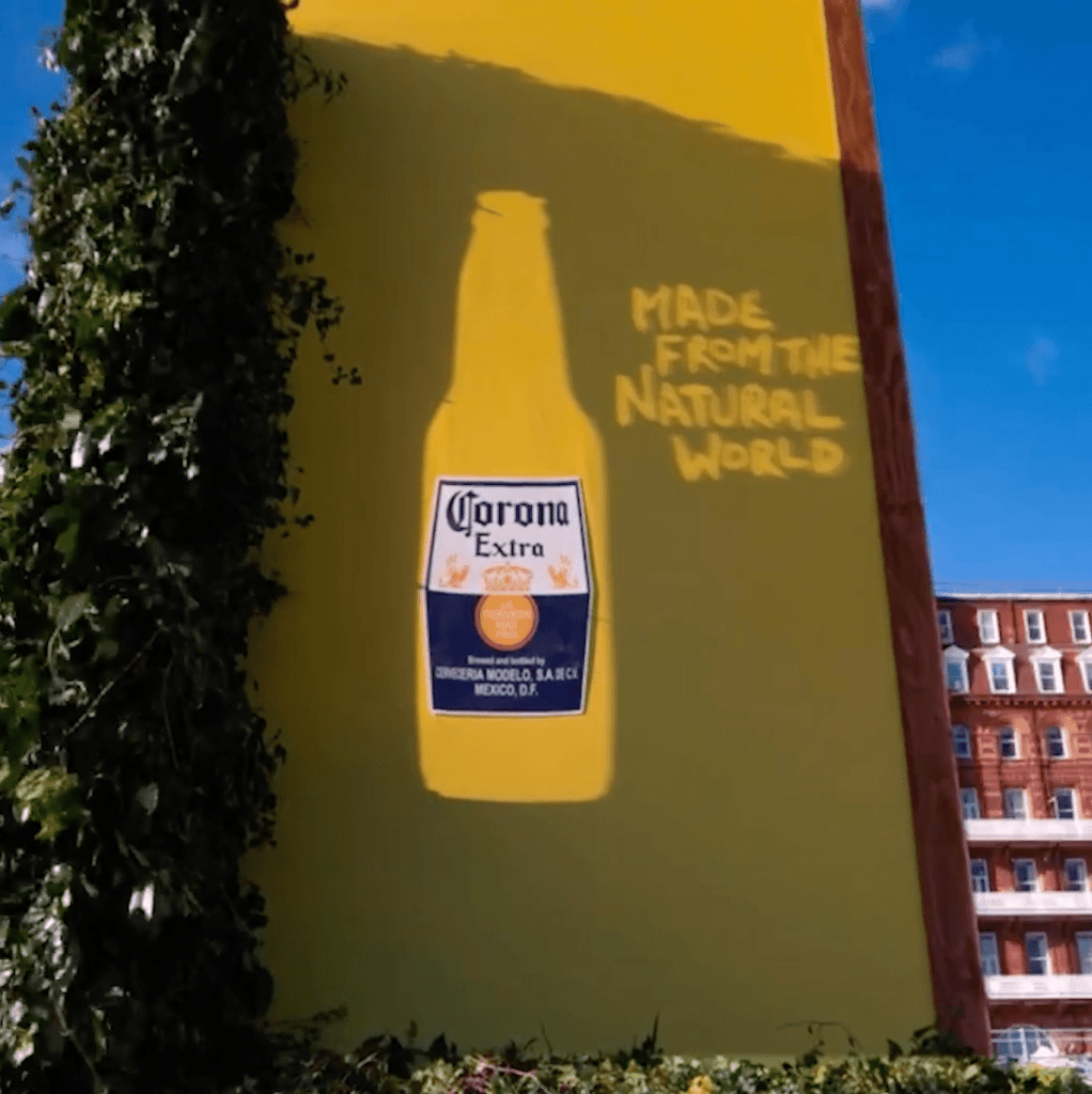 Shadows created at sunset to reveal the brand's bottle shape and a message on billboard. 