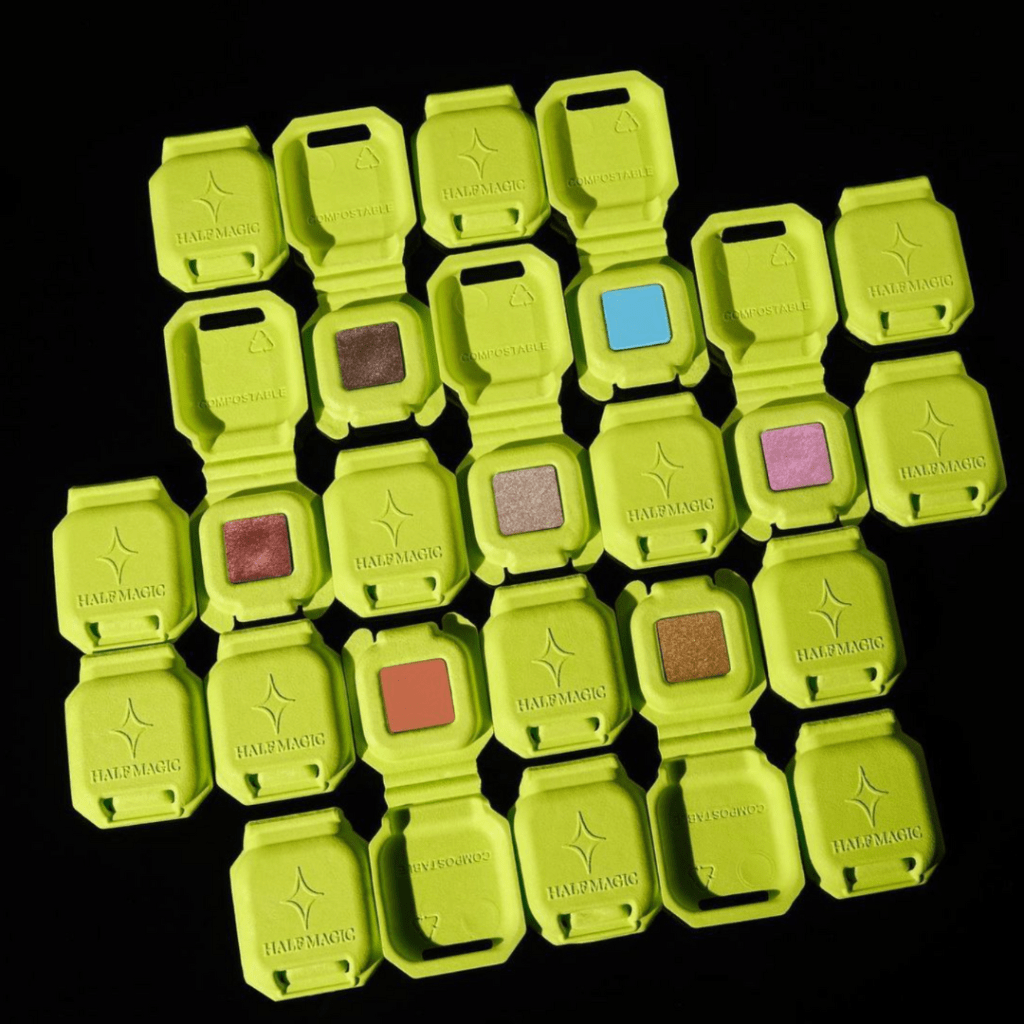 Bright neon green shades of egg cartons containing different colors of eye shadow.
